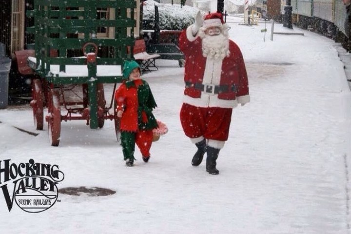 santa and elf walking by the train