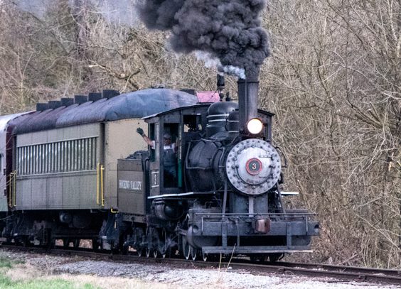 a train on a track with smoke coming out of it